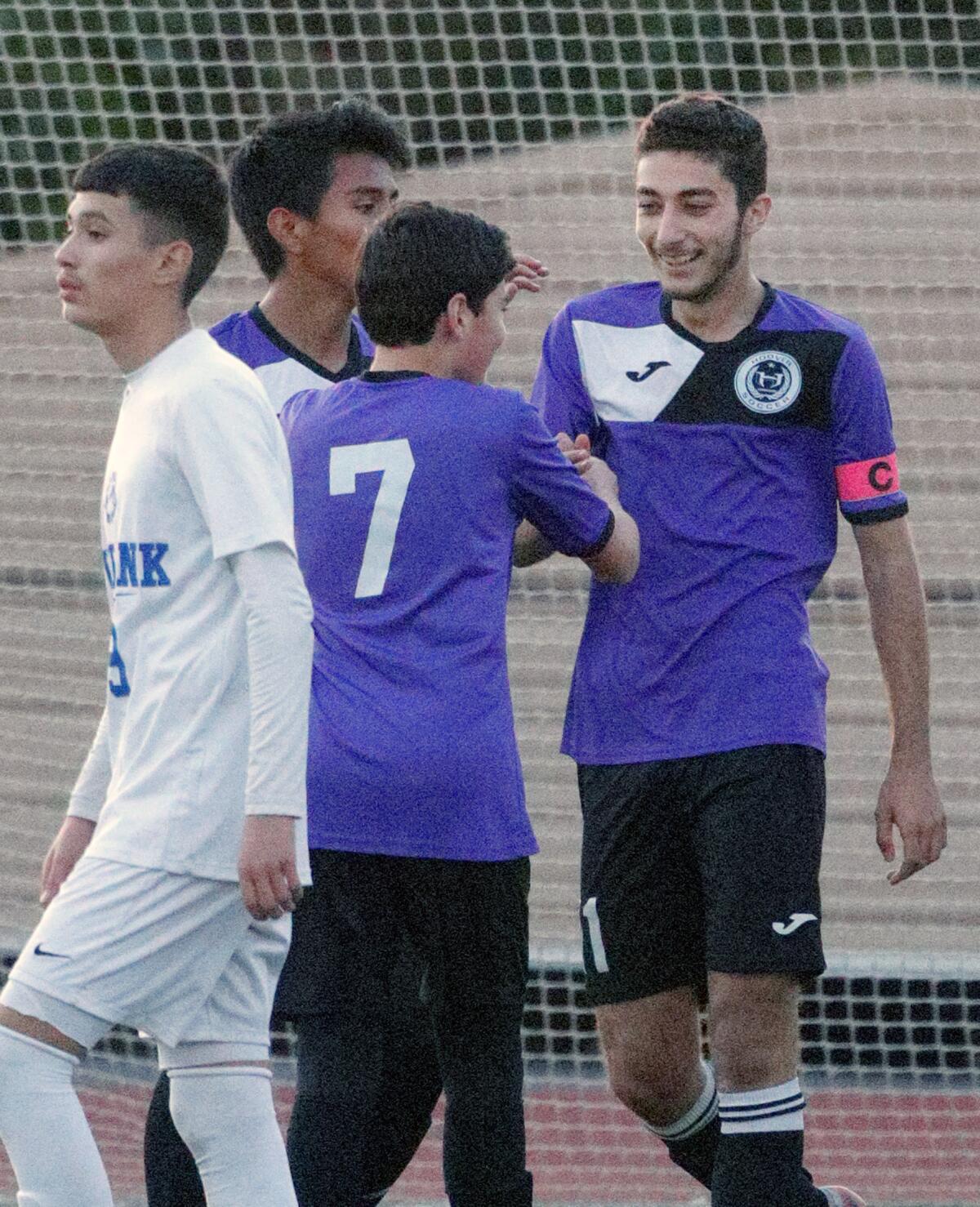 Hoover’s Kevin Mirzakhanian is congratulated by teammates after scoring his third goal of the game in a Pacific League boys' soccer game Friday against Burbank.