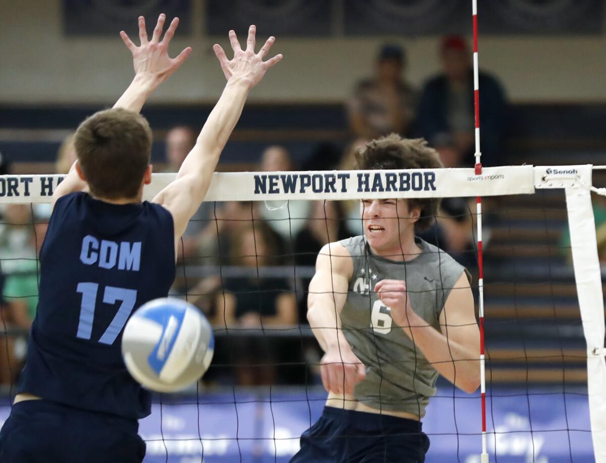 Newport Harbor's Jake Read (6) blasts a ball past Corona del Mar's Ryan Gant (17) during a boys' volleyball match.