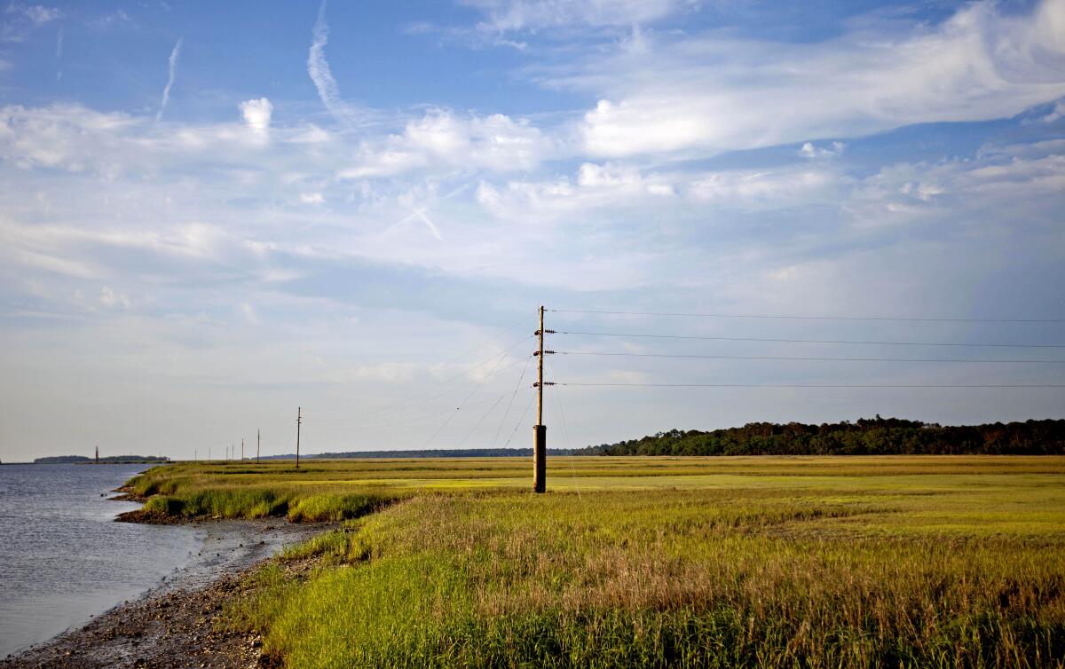 A utility pole stands in the middle of a marsh at sunset on Sapelo Island, Ga., a Gullah-Geechee community.