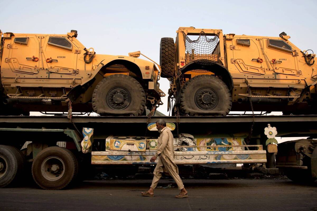 A truck carrying NATO military vehicles sits at a terminal in Karachi, Pakistan. Protesters have set up a blockade on a major highway into Afghanistan in hopes of ending the U.S. drone campaign in Pakistan.