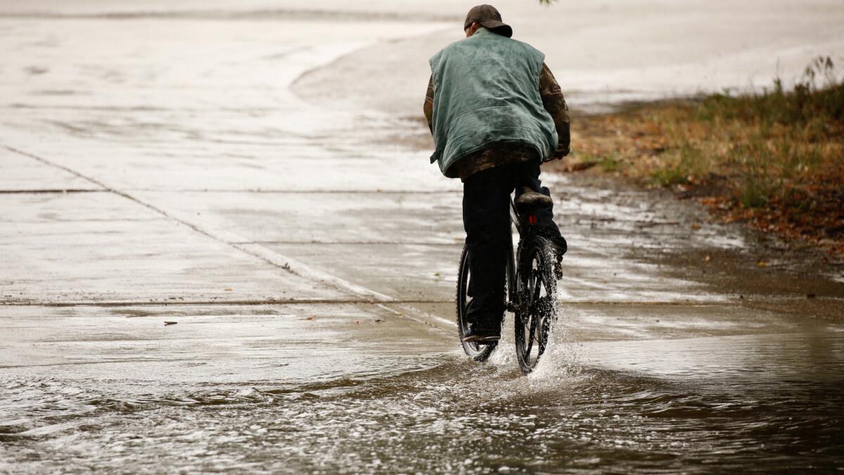 A cyclist finds wet riding conditions at the Hjelte Sports Center in Encino on May 16.