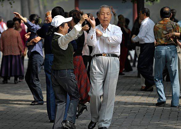 Elderly residents dance at the Temple of Heaven park in Beijing on April 30, 2009. China's aging population is a phenomenon that most economists speak about in ominous tones as they warn of the burden the elderly will become on national health and pension budgets.