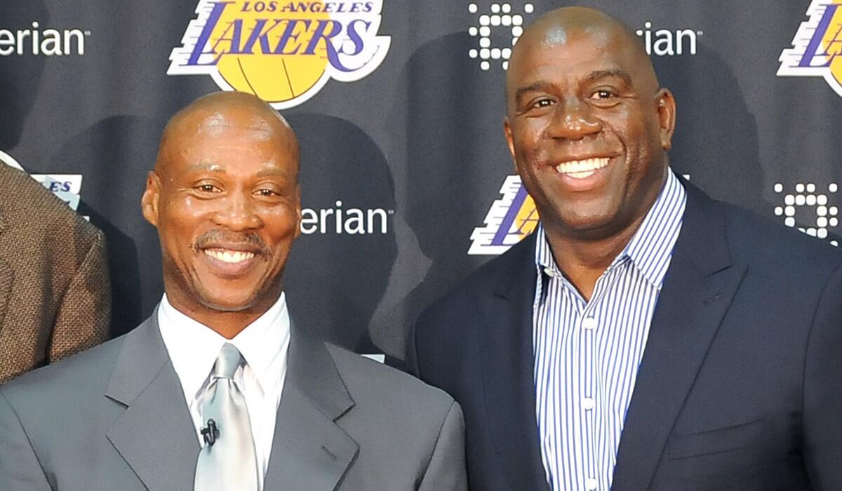 Lakers Coach Byron Scott, left, poses with former teammate Magic Johnson during a press conference at the team's training facility in El Segundo back in July.