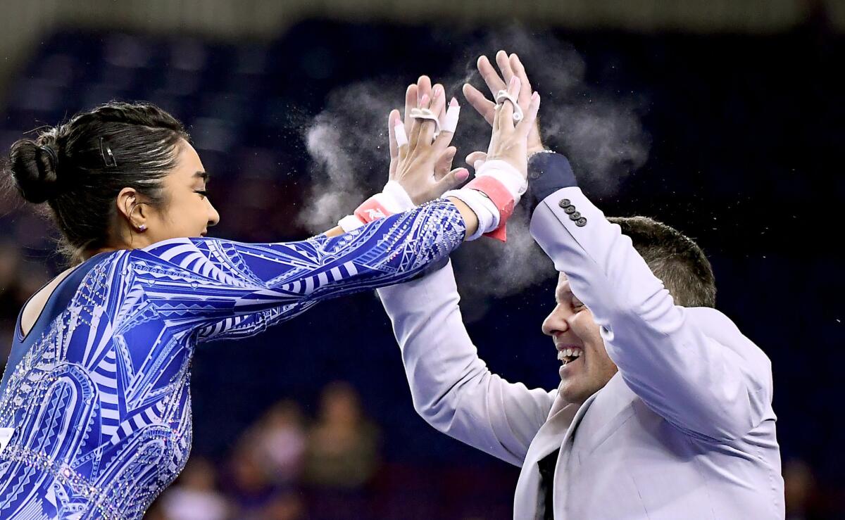 Felicia Hano celebrates with assistant coach Chris Waller after competing on the bars at the semifinals of the NCAA gymnastics championship at the Ft. Worth Convention Center on April 19.