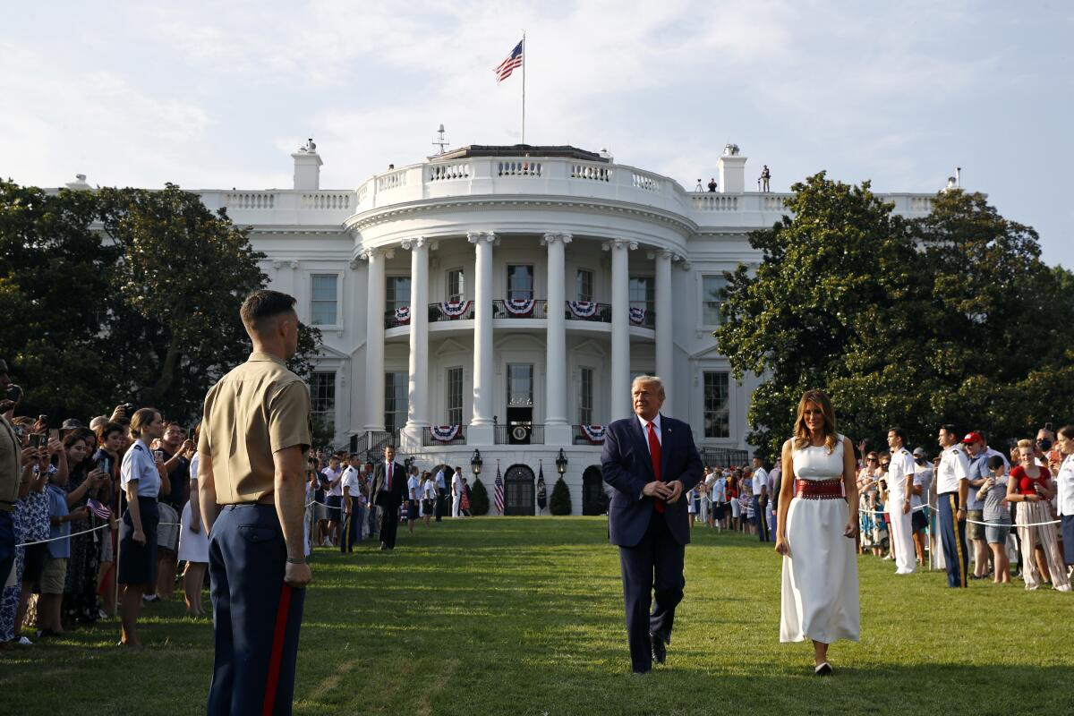 El presidente Donald Trump y la primera dama Melania Trump caminan por el jardín sur de la Casa Blanca.