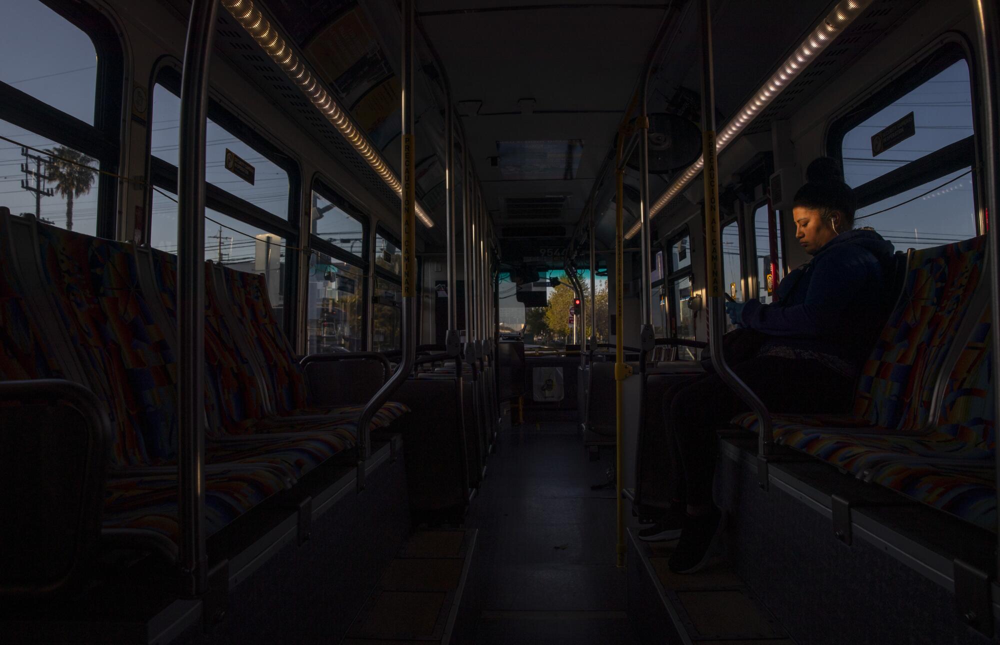 A woman rides an early-morning Orange Line bus in Canoga Park.