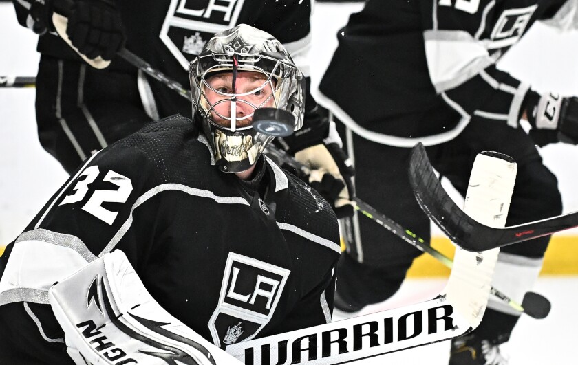 Kings goalie Jonathan Quick waves the puck fly past his helmet during the second period Sunday.