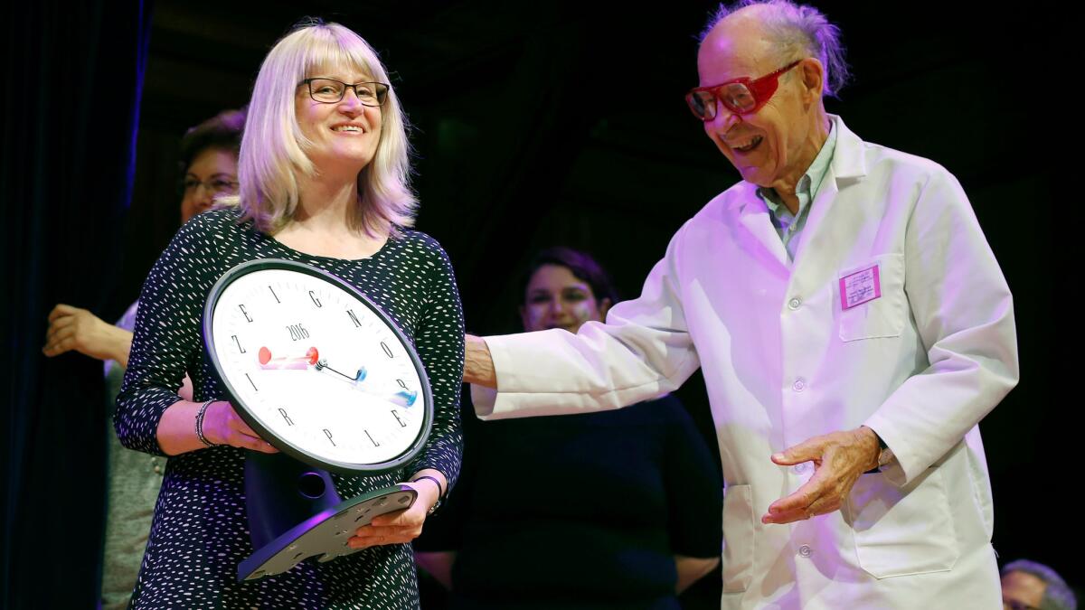 Susanne Akesson accepts the Ig Nobel Prize in physics from Nobel laureate Dudley Herschbach. Her work helped explain the behavior of insects.