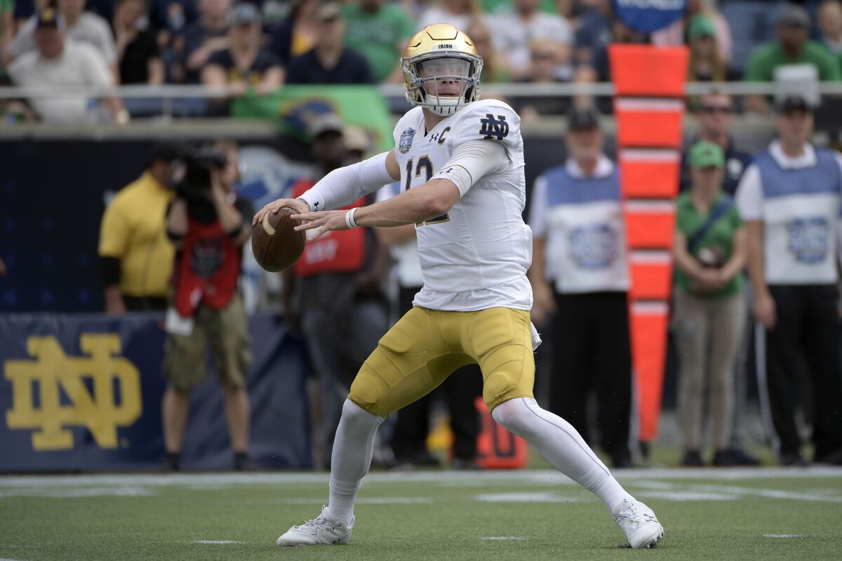 File-Notre Dame quarterback Ian Book (12) throws a pass during the first half of the Camping World Bowl NCAA college football game against Iowa State Saturday, Dec. 28, 2019, in Orlando, Fla. Head coach Brian Kelly has seen growth in the 6-foot, 208-pound Book since quarterbacks coach Tom Rees became the team’s new offensive coordinator prior to the team’s Camping World Bow victory over Iowa State. (AP Photo/Phelan M. Ebenhack, File)