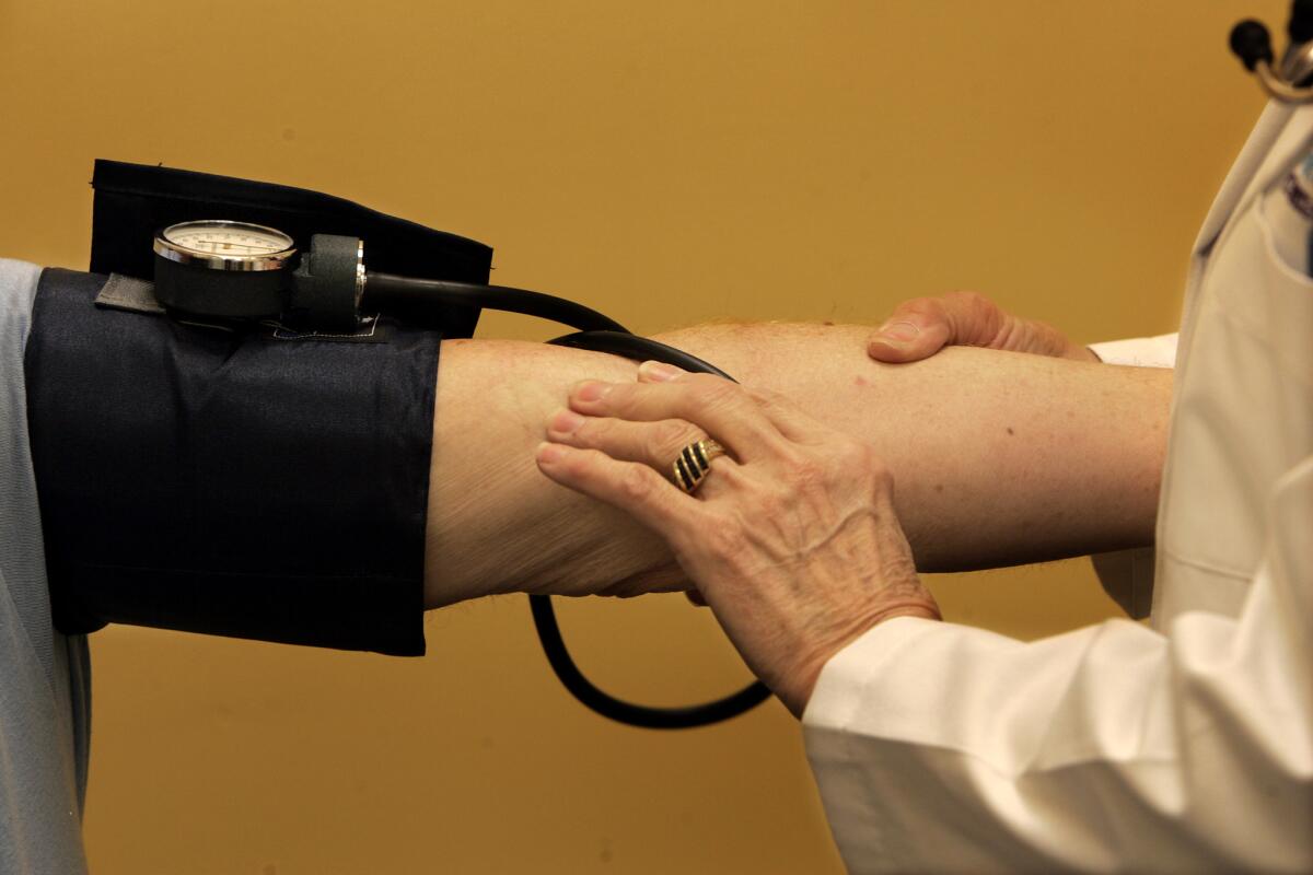 Nurse Practitoner Janet Schmitt checks the blood pressure on weight loss patient, Bill Curtis, 60, in January 2007 at the Lindora Health Clinic located in the Rite Aid Costa Mesa store. (Mark Boster, Los Angeles Times)