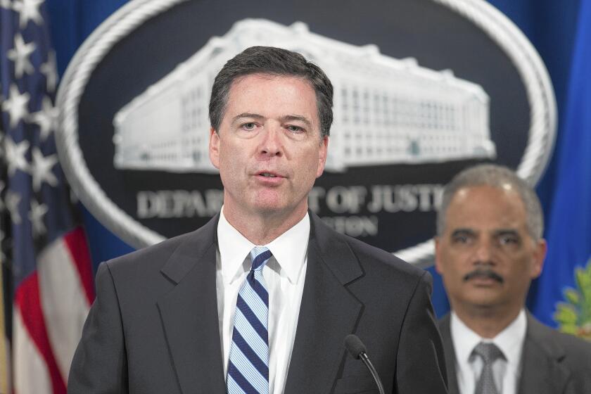 FBI Director James B. Comey, left, and U.S. Atty. Gen. Eric H. Holder Jr. announce a record $9-billion fine against the French bank BNP Paribas during a Justice Department news conference.