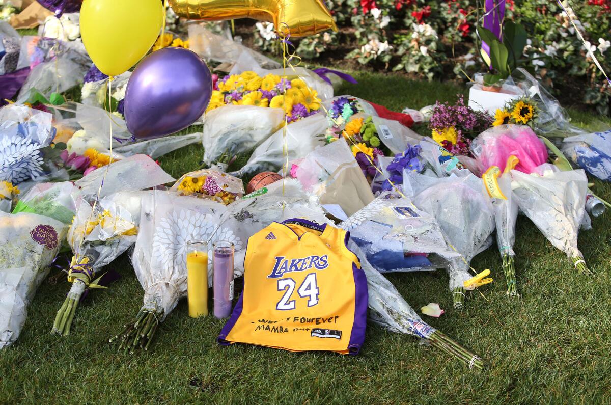 Lakers memorabilia and flowers and balloons in the team's purple and gold fill a shrine left by mourners outside Kobe Bryant's neighborhood, Pelican Crest in Newport Coast.