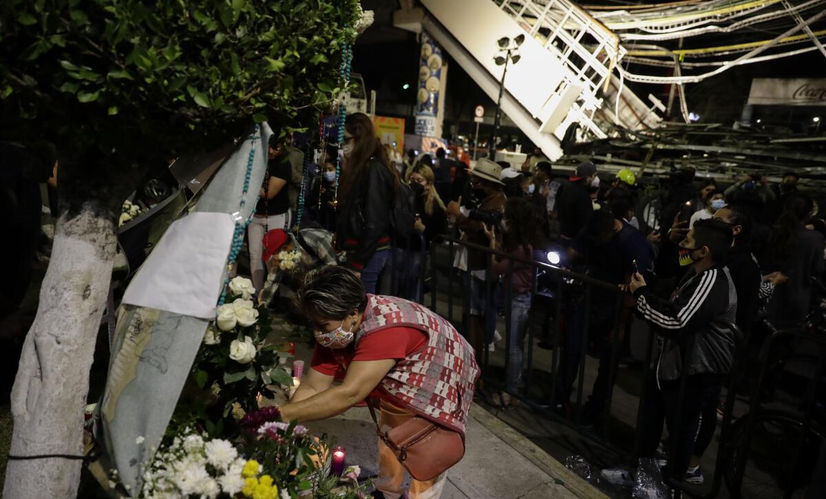 A woman places flowers at a makeshift altar  for the people who died in Monday's subway collapse