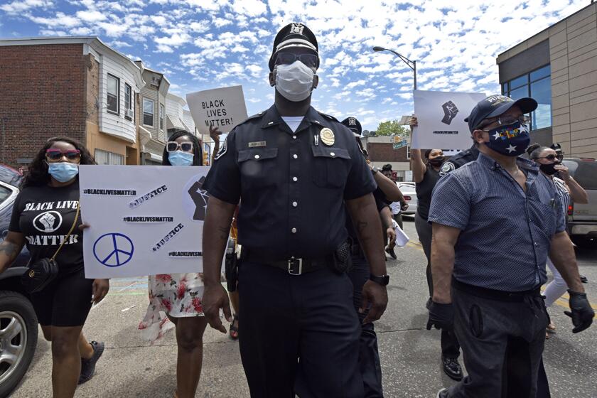 Lt. Zack James of the Camden County (N.J.) Metro Police Department marches along with demonstrators in Camden on Saturday to protest the death of George Floyd.