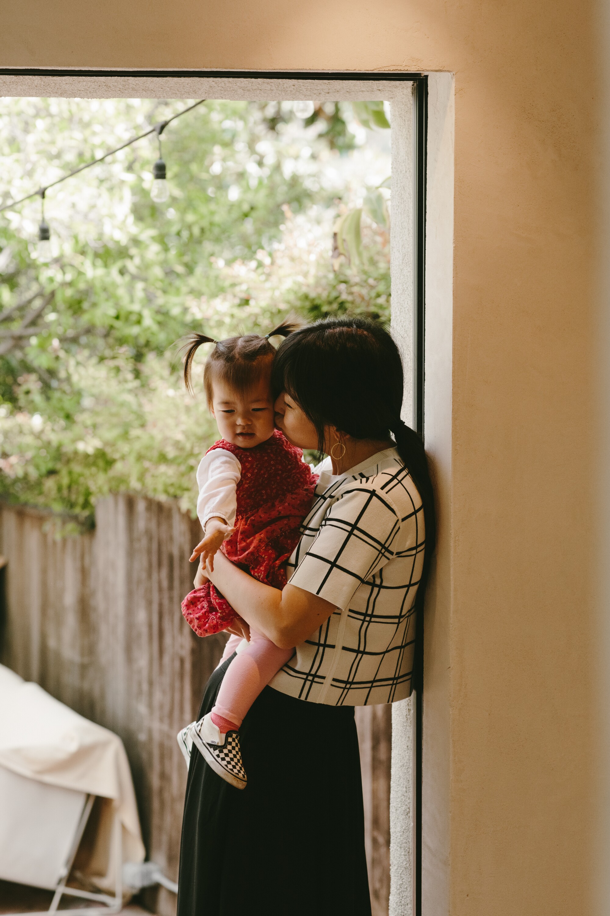 Writer Xuan Juliana Wang holds daughter, Esme, in their ADU.
