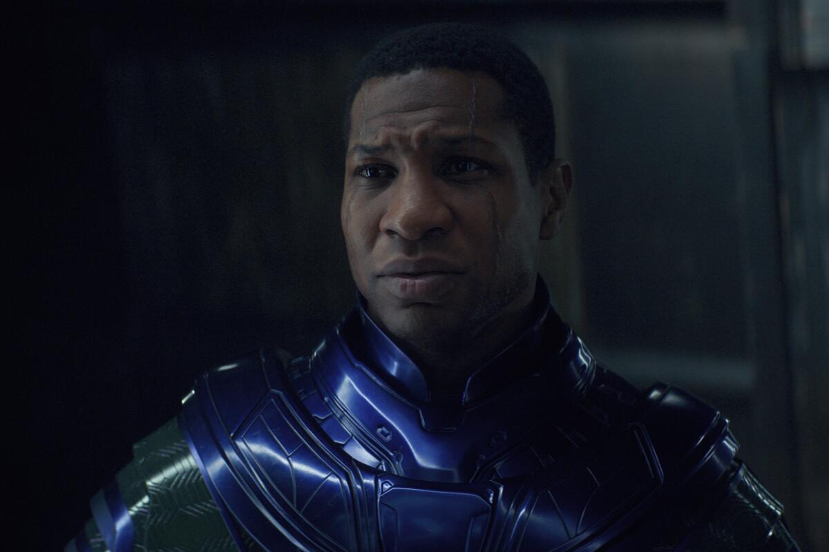 A man wearing blue metallic armor and looking concerned