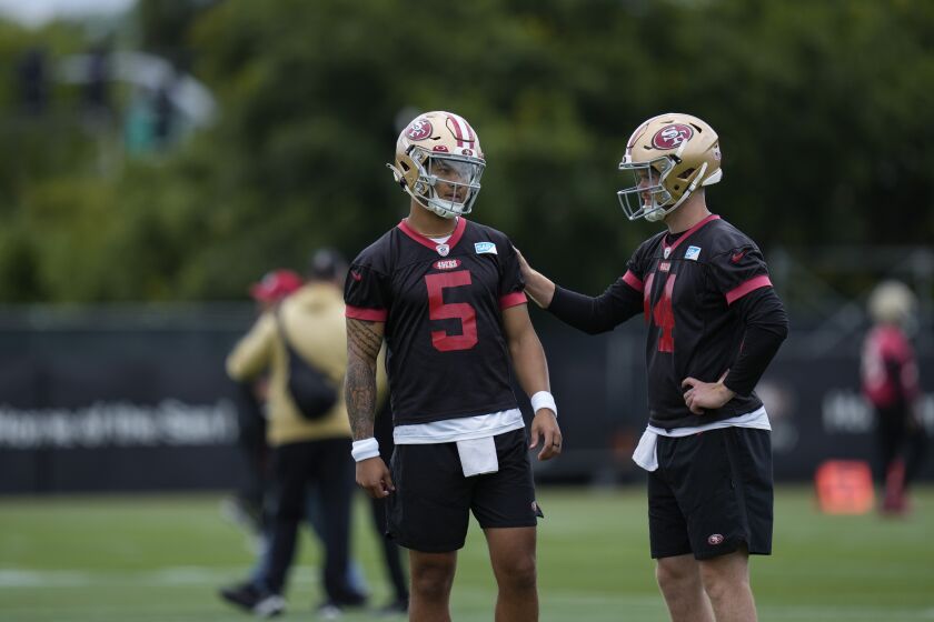 San Francisco 49ers' Trey Lance, left, speaks with fellow quarterback Sam Darnold, right, during an NFL football practice, Wednesday, June 7, 2023, in Santa Clara, Calif. (AP Photo/Godofredo A. Vásquez)