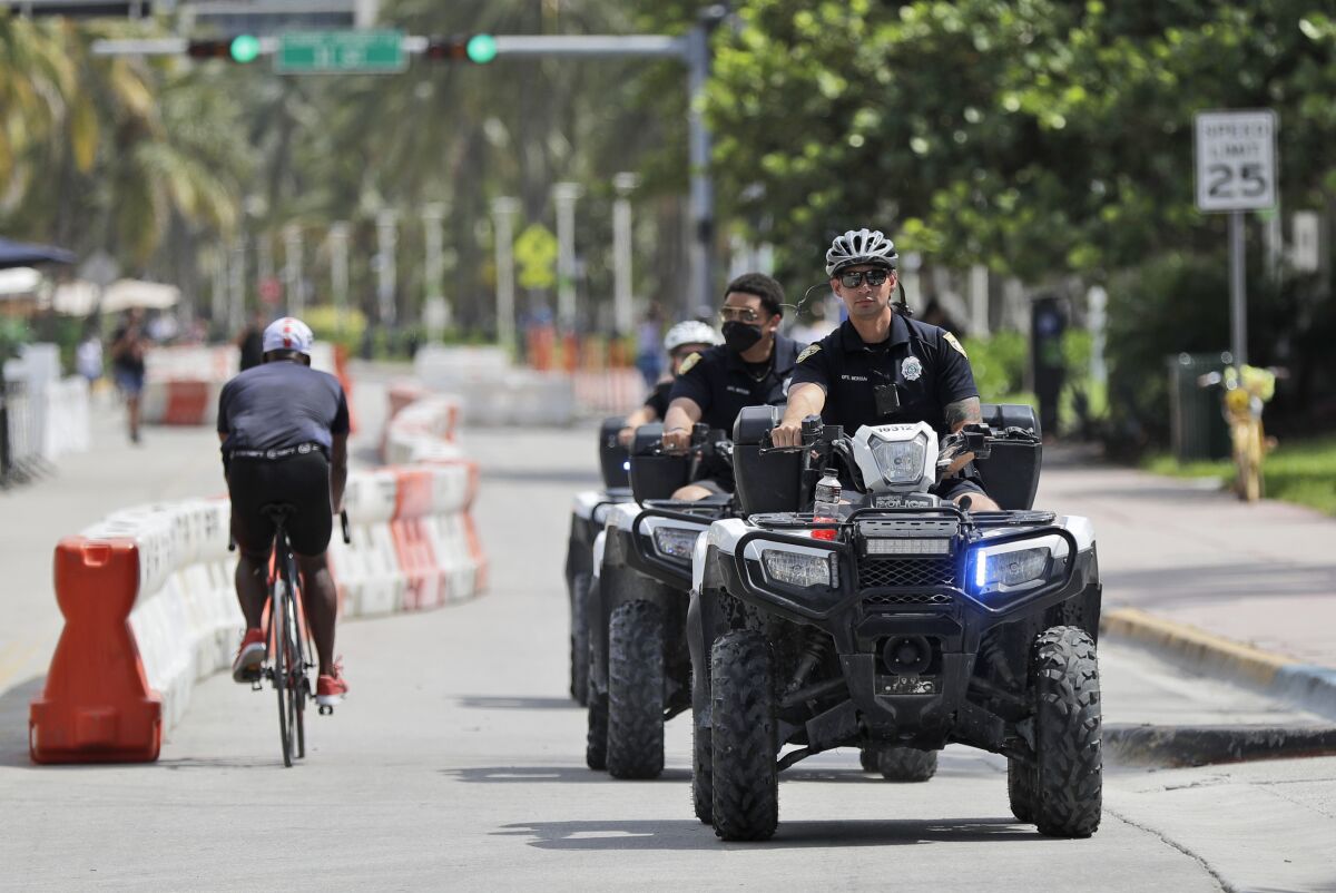 Police officers riding all terrain vehicles patrol Miami Beach, Florida's famed Ocean Drive on South Beach, July 4, 2020. The Fourth of July holiday weekend began Saturday with some sobering numbers in the Sunshine State: Florida logged a record number of people testing positive for the coronavirus. (AP Photo/Wilfredo Lee)