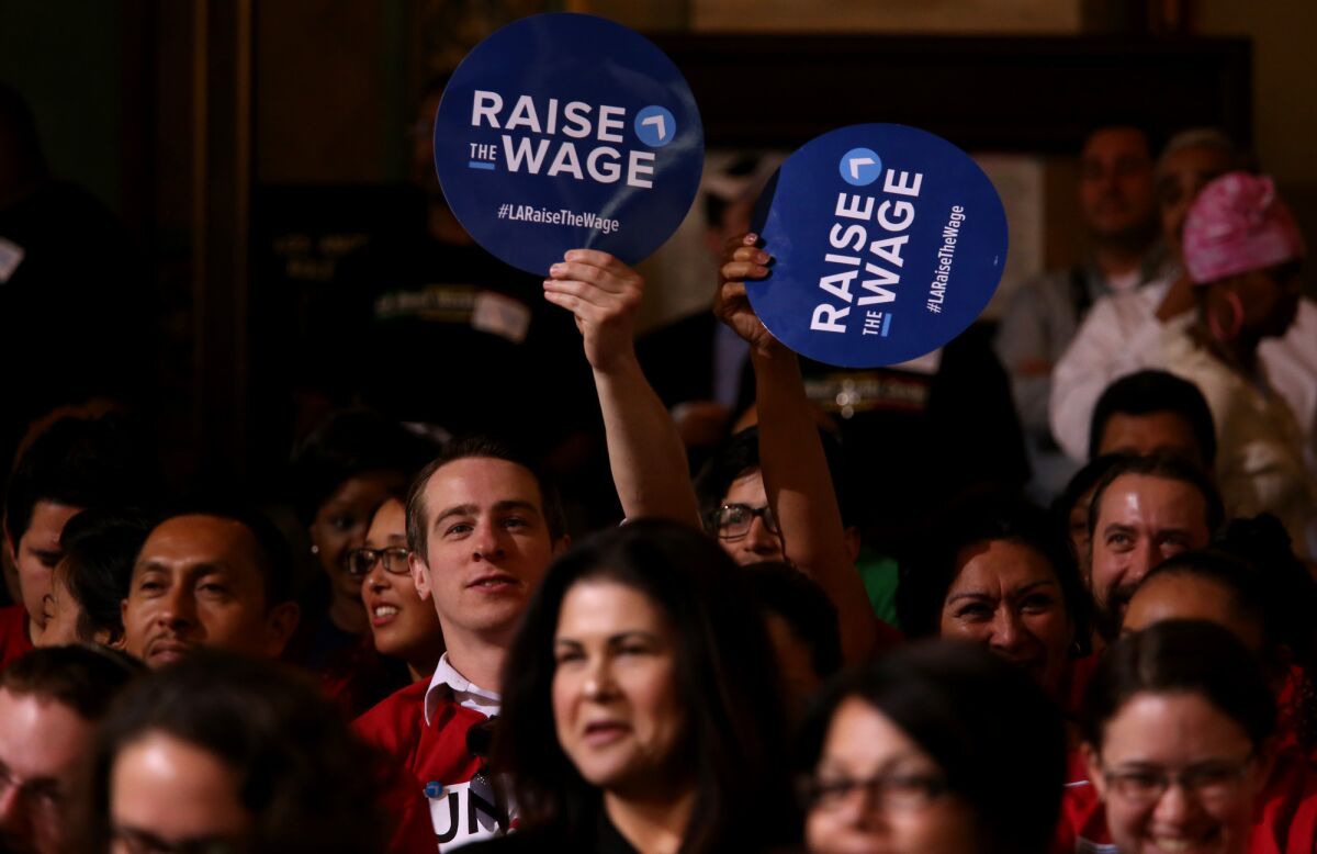 Members of Unite Here show their support for raising the minimum wage before the Los Angeles City Council vote.