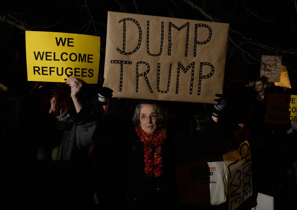 A woman holds a sign outside the hotel where Republican presidential candidate Donald Trump is due to speak in Portsmouth, N.H. on Dec. 10.