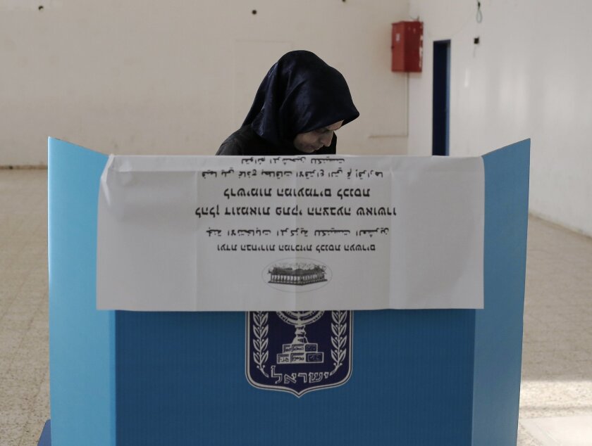 An Arab Israeli woman prepares to cast her ballot at a polling station in the northern Israeli town of Umm al-Fahm on March 17.