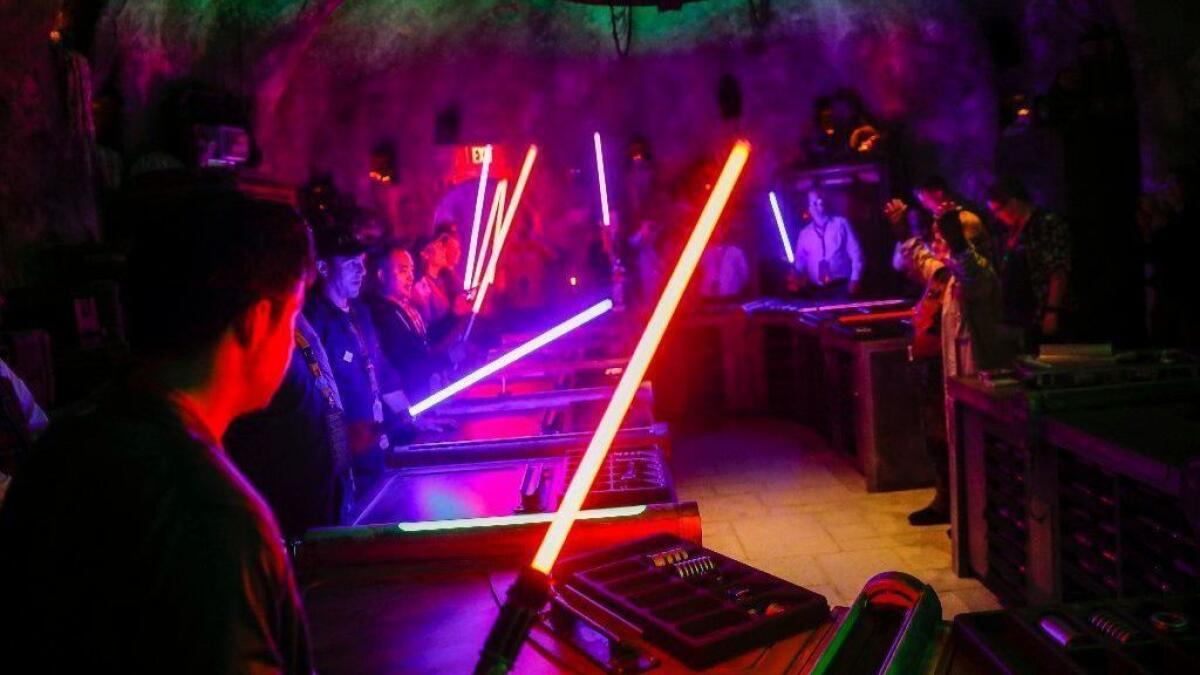 Visitors learn about their lightsabers at Savi's Workshop in Star Wars: Galaxy's Edge.