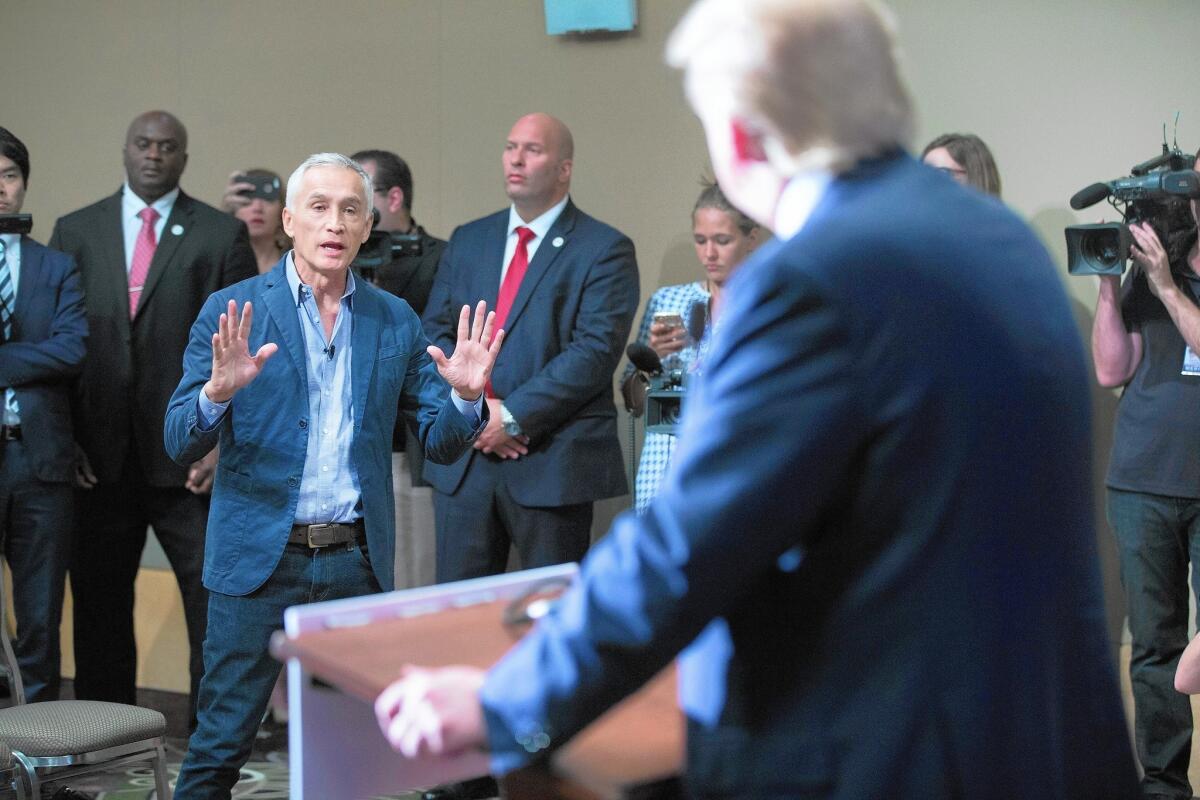 Jorge Ramos directs questions to GOP presidential candidate Donald Trump, right, at news conference.