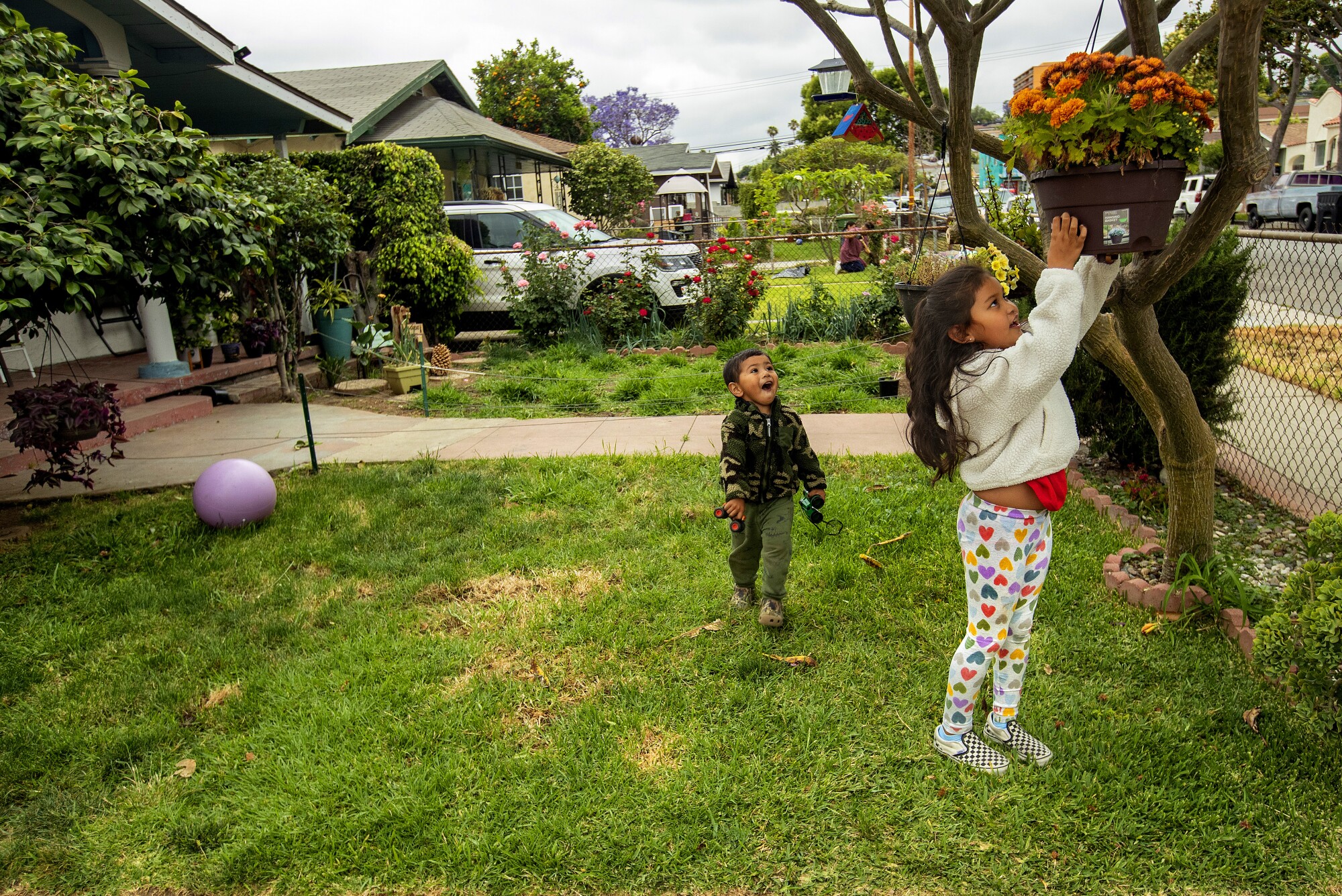 Erick García y su hermana Aryanna juegan en el jardín delantero de su casa.