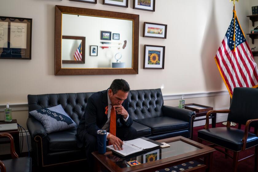 Rep. Pete Aguilar (D-CA) reads through some paper, making notes as he goes, in his office on Capitol Hill.