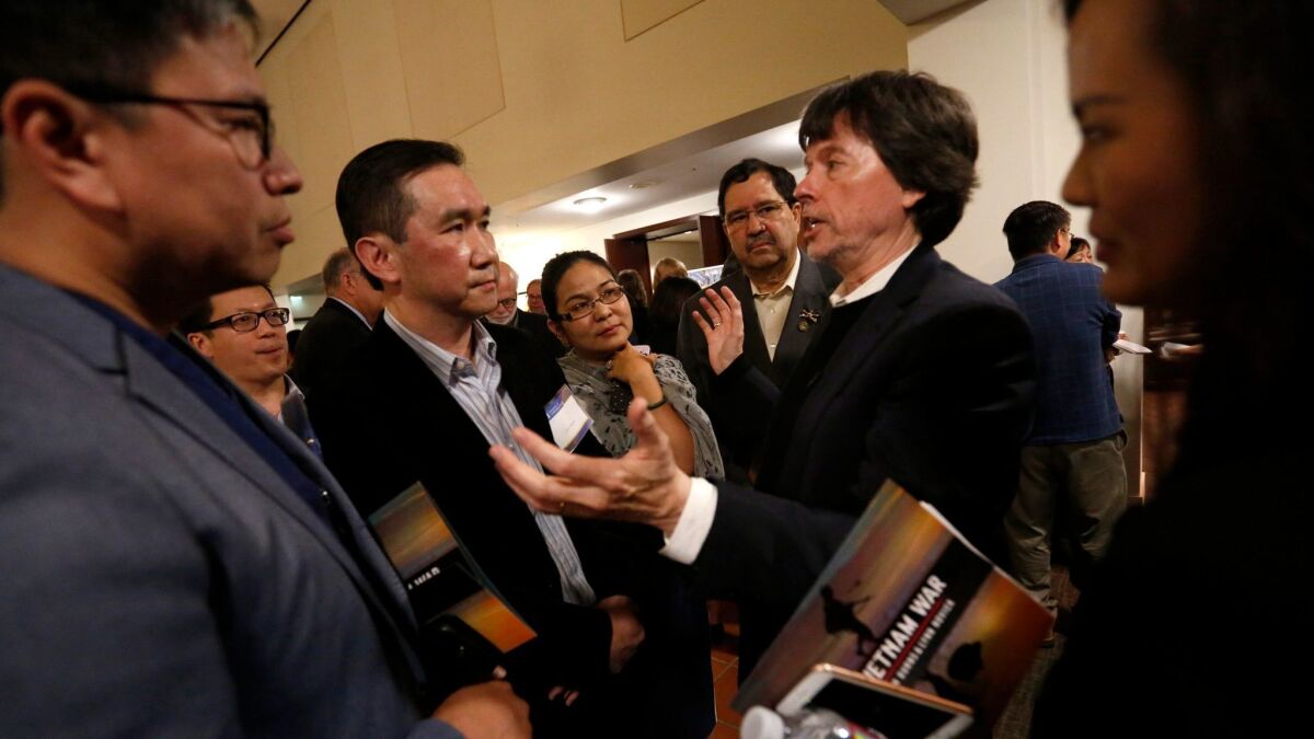 Documentary filmmaker Ken Burns, second from right, speaks with Dr. Thomas Tri Quach, left, Dr. Quan Nguyen, in dark suit, and other immigrants after screening of episodes from his upcoming work, "The Vietnam War."