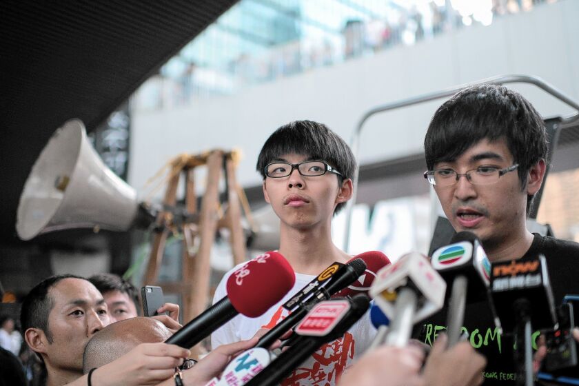 Alex Chow, head of the Hong Kong Federation of Students, speaks to reporters on Oct. 4. Next to him is Joshua Wong, 17, leader of a high school activist group.
