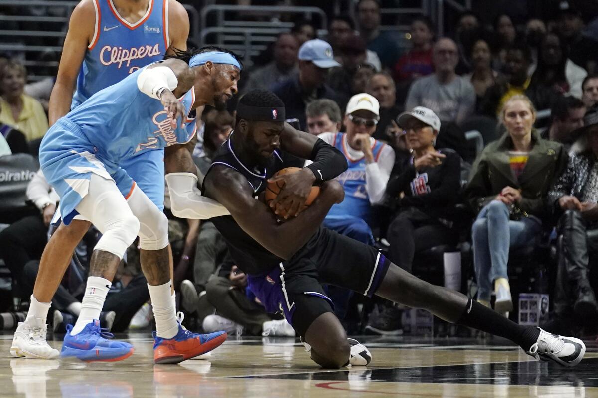 Sacramento Kings center Neemias Queta grabs the ball next to Clippers forward Robert Covington.