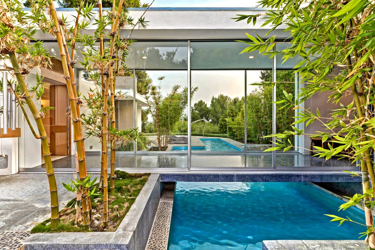 Home of the Week in Beverly Hills has a swimming pool walkway that bridges the main bedroom suite. 
