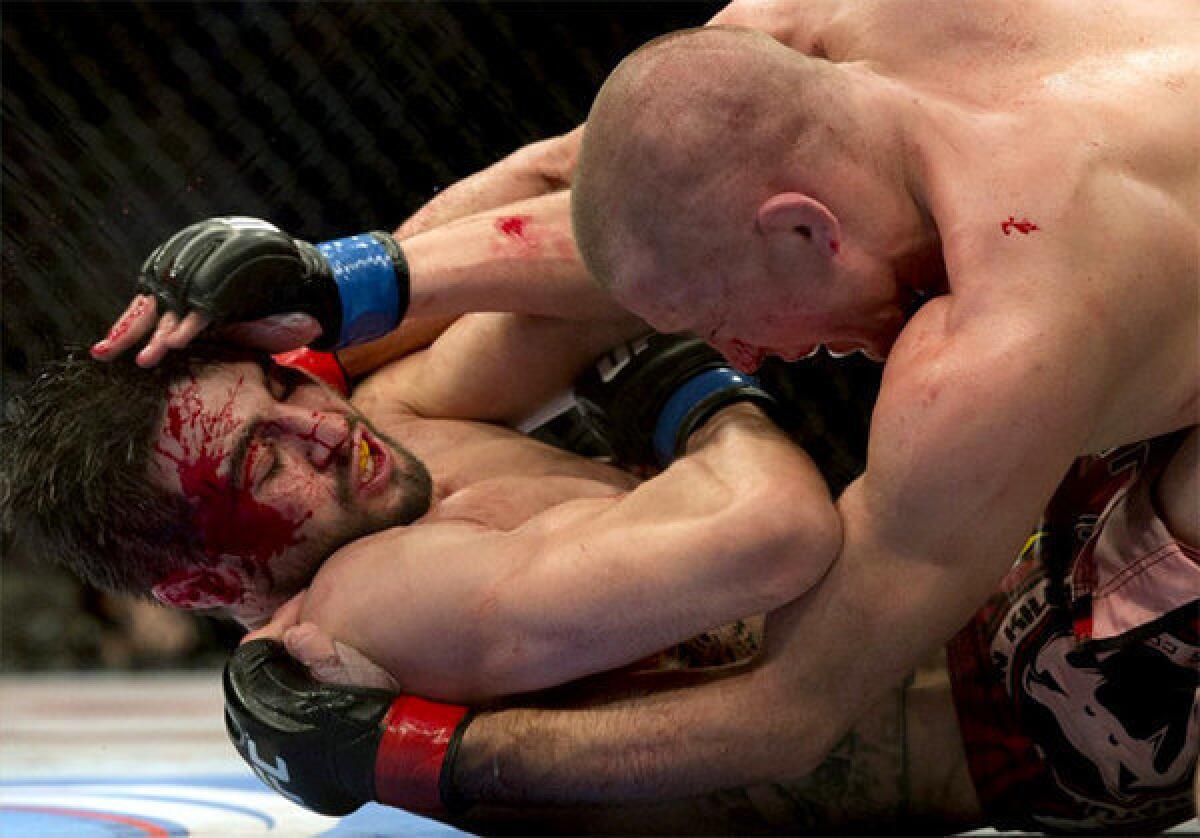 Carlos Condit, bottom, battles with Georges St-Pierre during their UFC welterweight title fight.