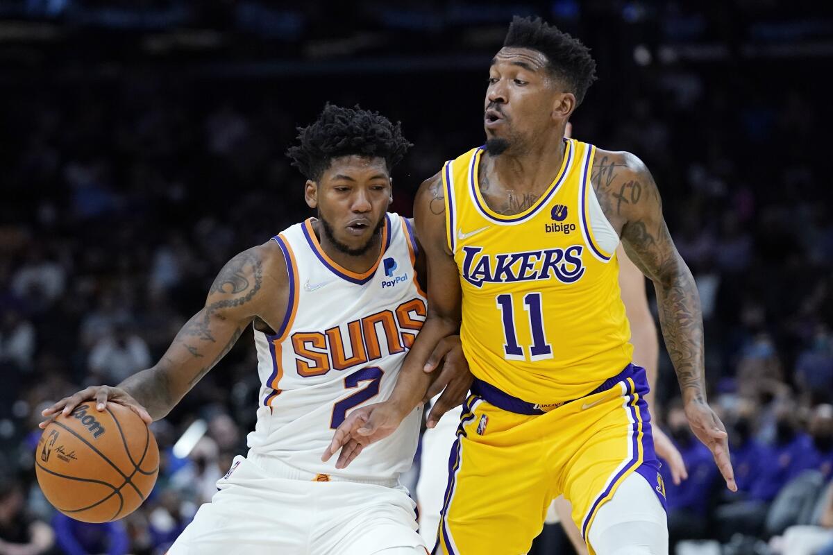 The Lakers' Malik Monk tries to cut off  Suns guard Elfrid Payton.
