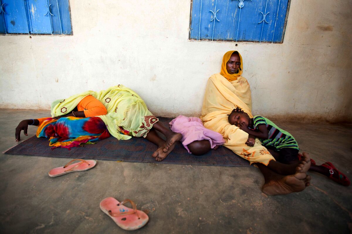 Sick women and children wait to be treated for malaria at a hospital in El Sereif village in North Darfur, Sudan.