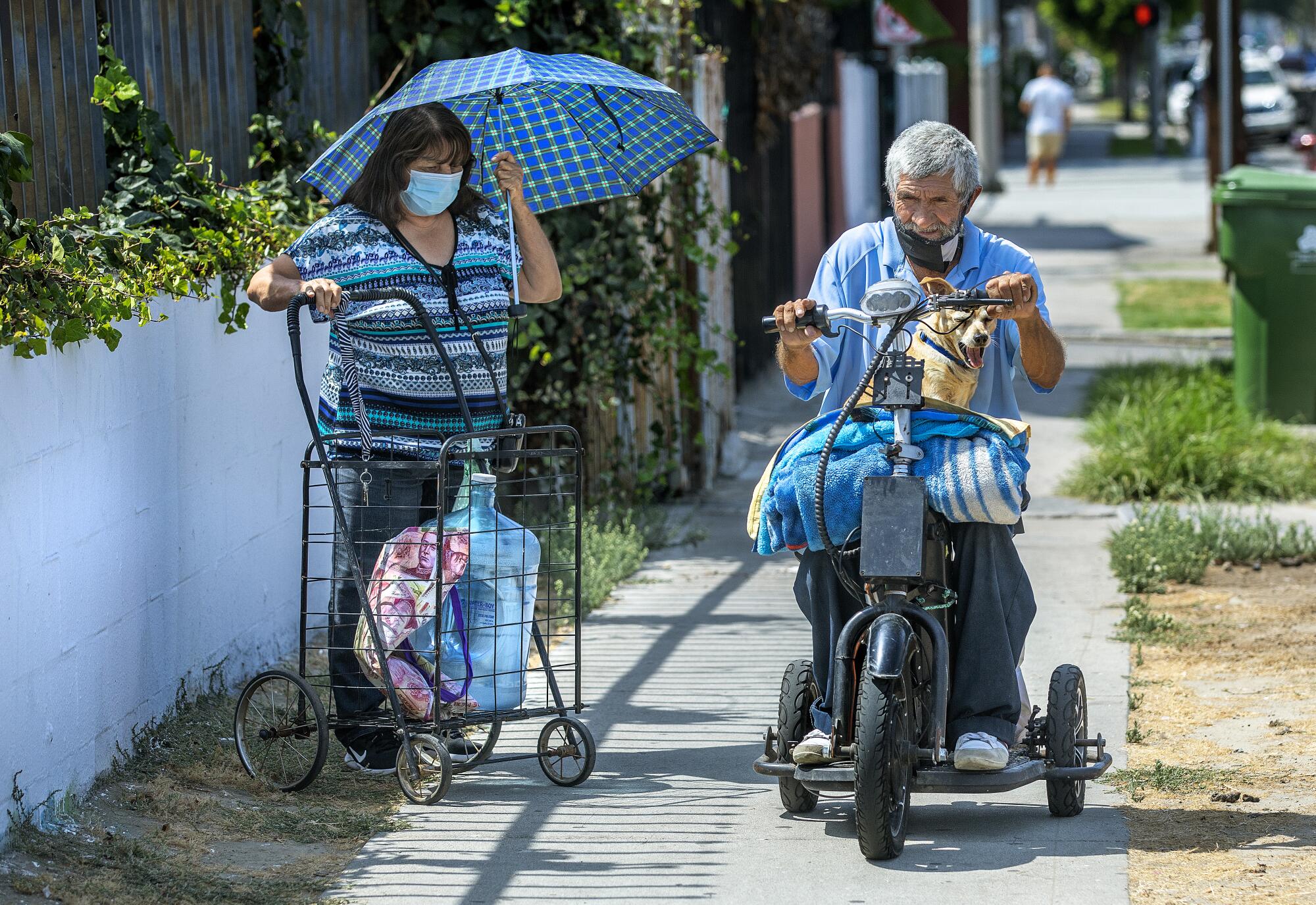 Augustine Hurtado rides his scooter along Central Avenue in Los Angeles with his dog, Sparky.