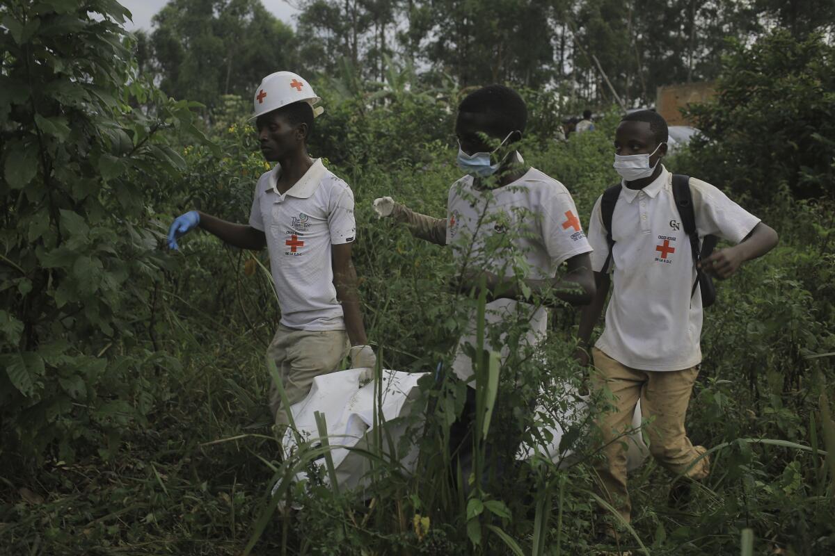 Red Cross volunteers carrying a body