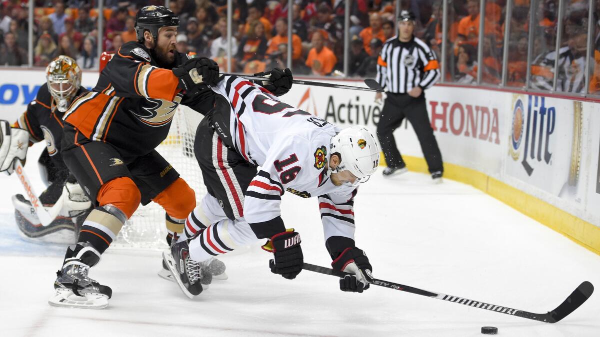 Anaheim Ducks defenseman Clayton Stoner, left, pushes Chicago Blackhawks center Marcus Kruger off the puck during the first period of Game 2 of the Western Conference finals at Honda Center on May 19, 2015.
