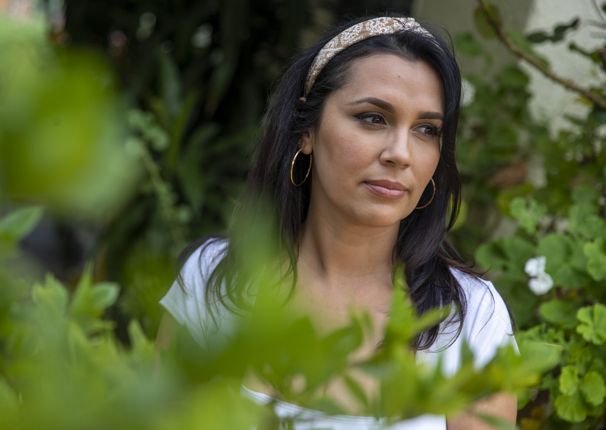 Crystal Ryan is shown surrounded by leafy plants