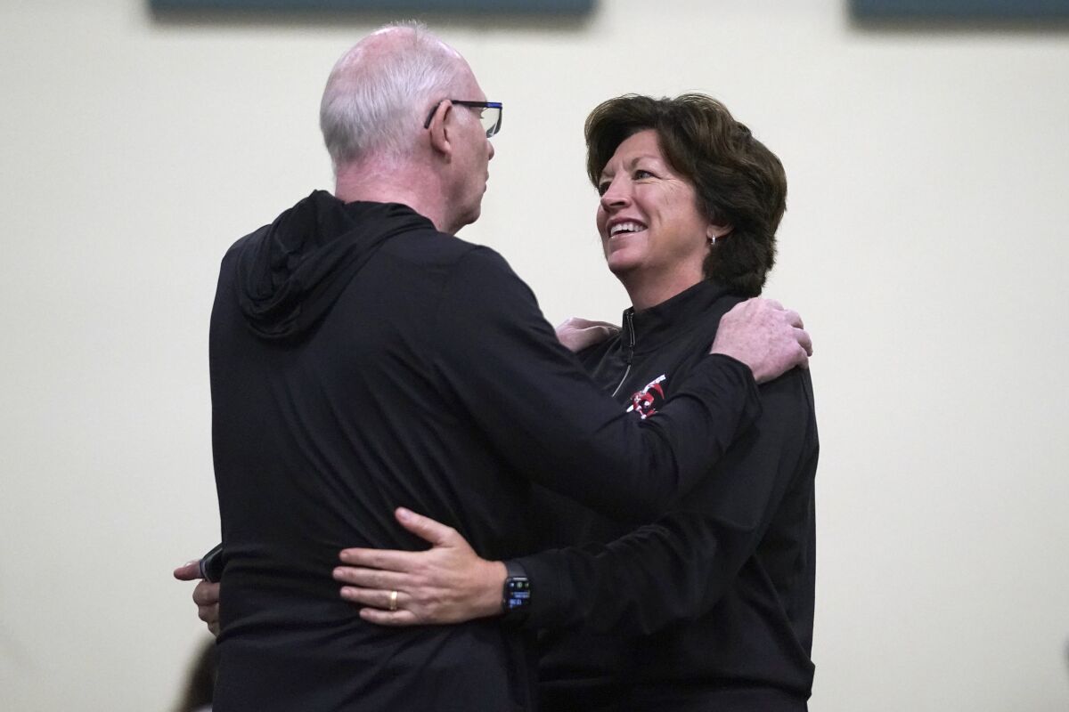 Miami men's head coach Jim Larranaga, left, and woman's head coach Katie Meier greet each other during the NCAA college basketball team's media day, Tuesday, Oct. 26, 2021, in Coral Gables, Fla. (AP Photo/Wilfredo Lee)