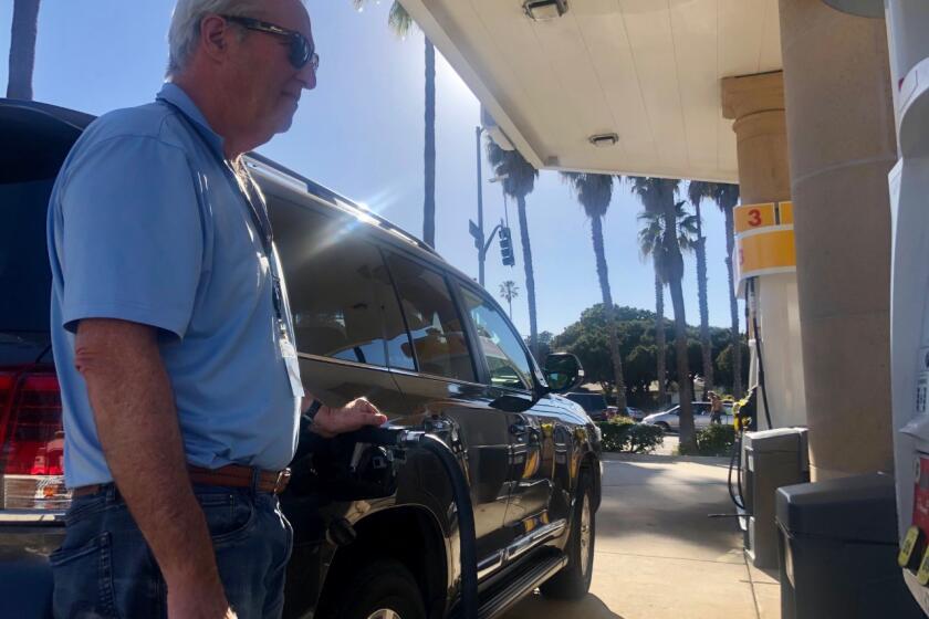 Guy Stone of La Jolla fills up the tank of his SUV T at a Shell station. 