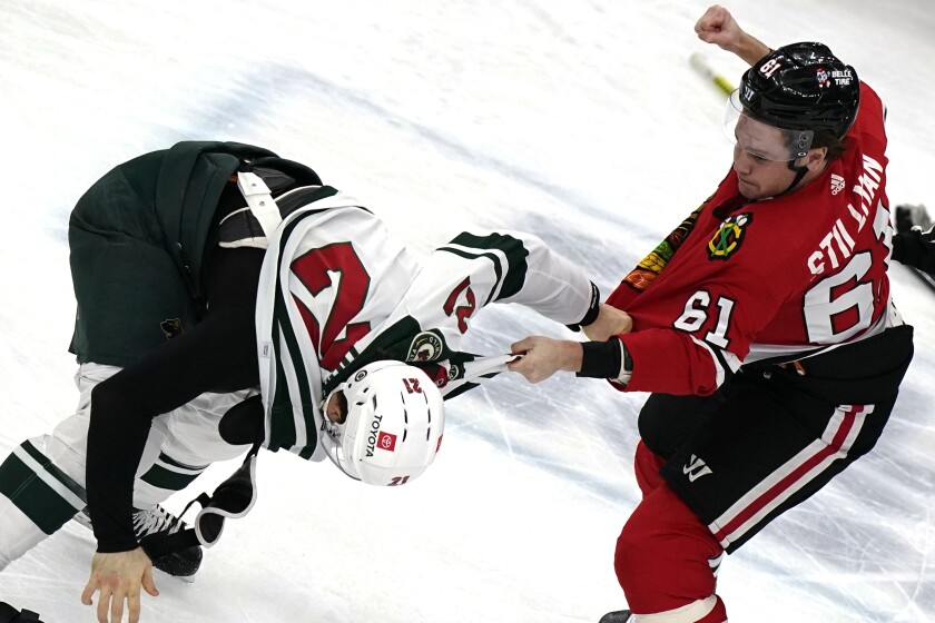 Chicago Blackhawks defenseman Riley Stillman, right, and Minnesota Wild right wing Brandon Duhaime fight during the first period of an NHL hockey game in Chicago, Friday, Jan. 21, 2022. (AP Photo/Nam Y. Huh)