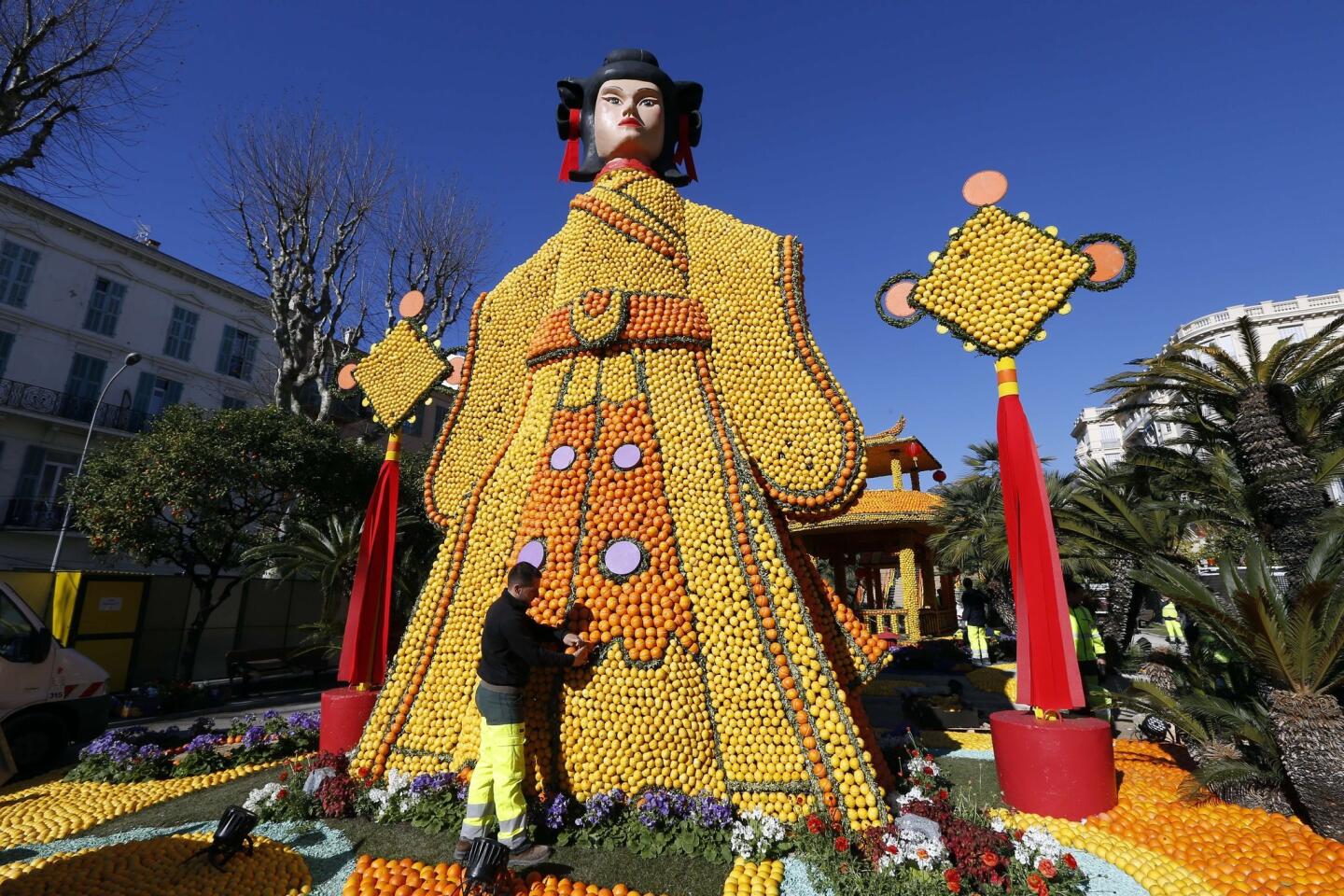 People work on a sculpture, made of oranges and lemons in Menton on the French Riviera, ahead of the start of the "Fete du Citron".