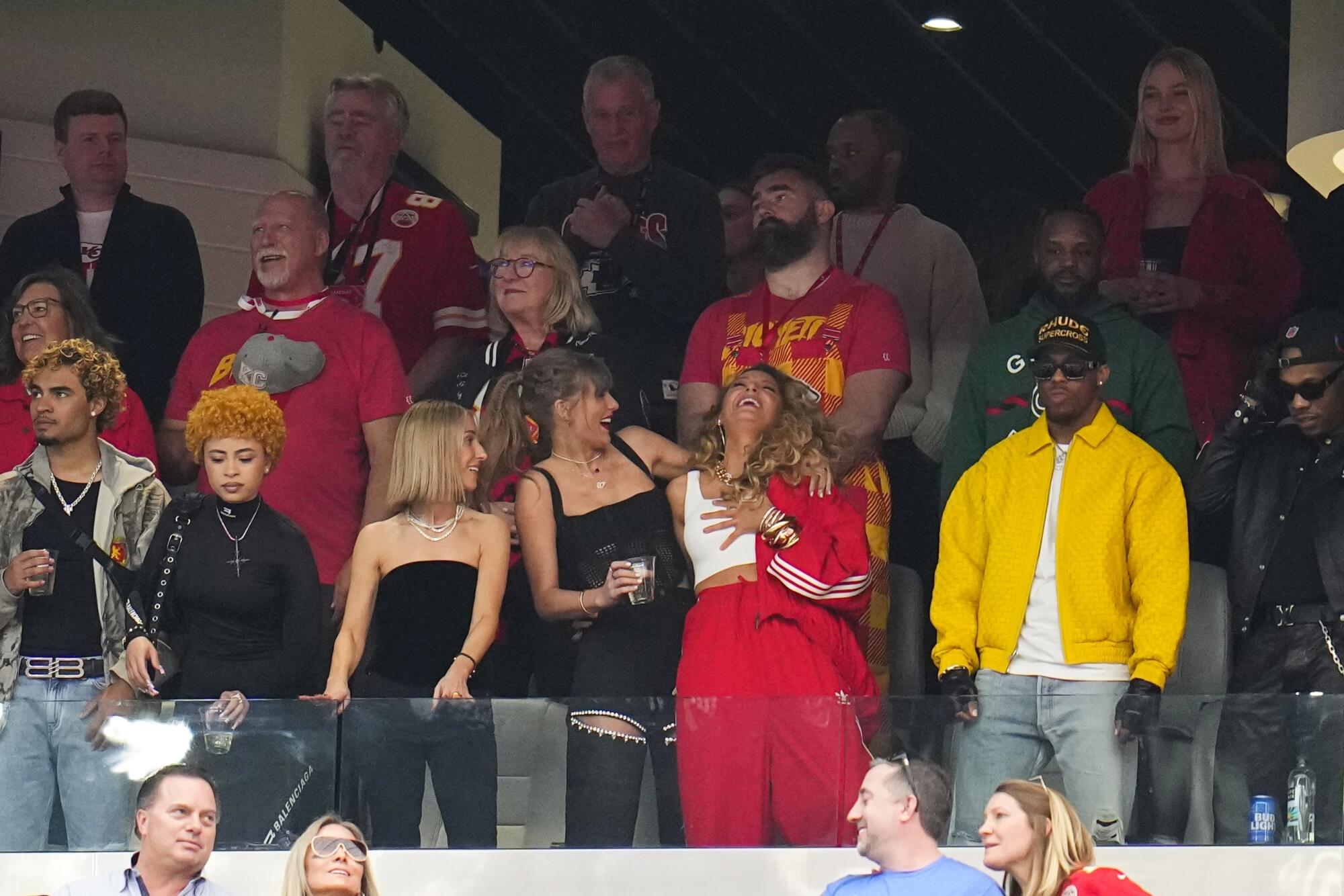 Taylor Swift, en bas à gauche, et Blake Lively rient avant le match 