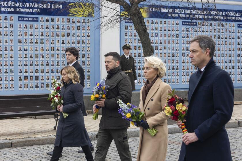 In this photo provided by the Ukrainian Presidential Press Office, Belgian Prime Minister Alexander De Croo, EU Commission President Ursula von der Leyen, Ukrainian President Volodymyr Zelenskyy, Italy's Premier Giorgia Meloni, Canadian Prime Minister Justin Trudeau, from right to left, attend laying flowers ceremony at the Wall of Remembrance to pay tribute to killed Ukrainian soldiers, in Kyiv, Ukraine, Saturday, Feb. 24, 2024. President Volodymyr Zelenskyy has welcomed Western leaders to Kyiv to mark the second anniversary of Russia's full-scale invasion, as Ukrainian forces run low on ammunition and foreign aid hangs in the balance. (Ukrainian Presidential Press Office via AP)
