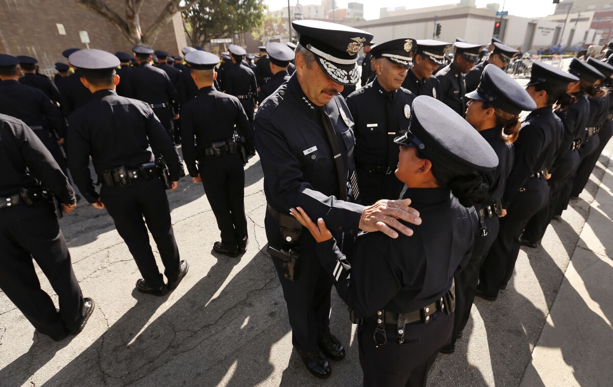LAPD Chief Charlie Beck talks with Officer Michelle Garcia as he conducts his last formal inspection outside Central station.