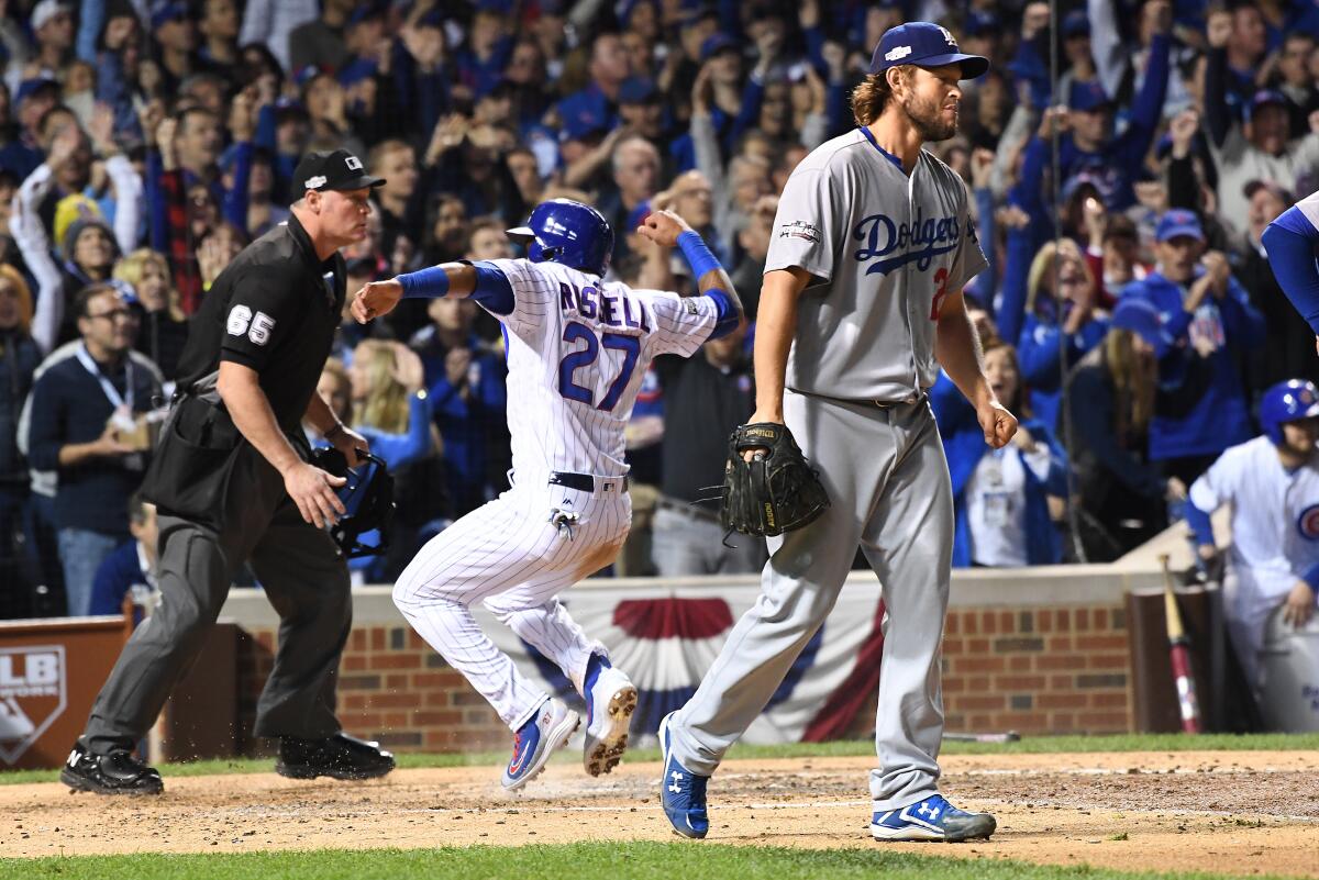 Dodgers pitcher Clayton Kershaw walks back to the mound as Chicago's Addison Russell scores a run.