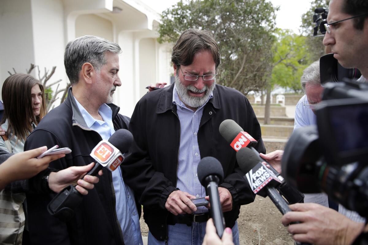 Richard Martinez, center, who says his son Christopher Michaels-Martinez was killed in Friday night's attack in Isla Vista, is comforted by his brother, Alan, as he talks to media outside the Santa Barbara County Sheriff's headquarters.