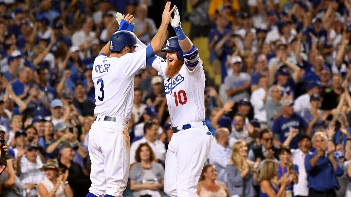 Dodgers center fielder Chris Taylor (3) congratulates Justin Turner after he hit a two-run home run against the Astros during the sixth inning of Game 1.